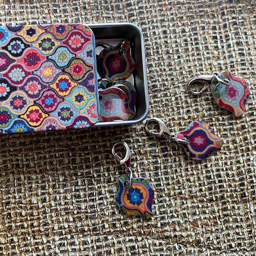 Mystical Lanterns crochet stitch markers in a pocket tin